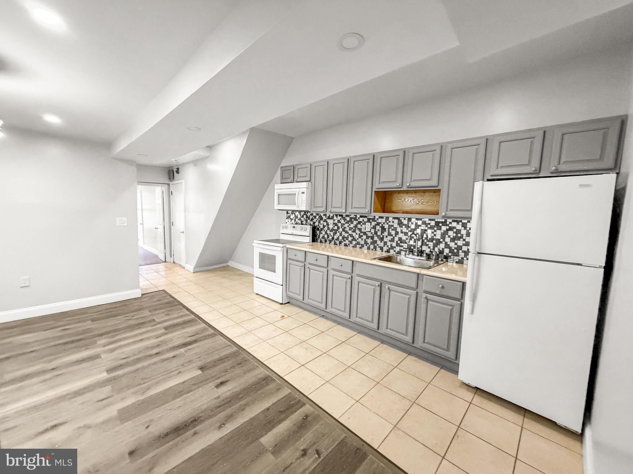a kitchen with white cabinets and white appliances