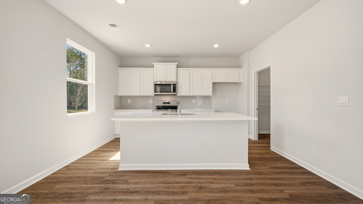8578 Seabiscuit Road Lithonia, GA 30058 - Photo 9 of 30 a white kitchen with wooden floor