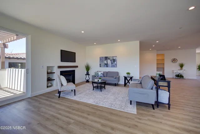 a living room with furniture a fireplace and a flat screen tv