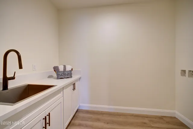 a kitchen with a sink and a white wooden floor