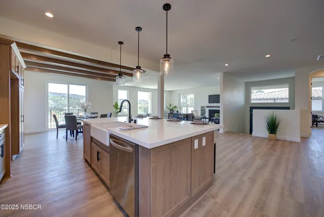 a kitchen with kitchen island a sink appliances and wooden floor