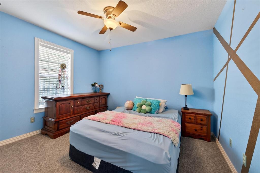 207 Gayle Circle Bells, TX 75414 - Photo 21 of 30 a bedroom with a bed and a chandelier