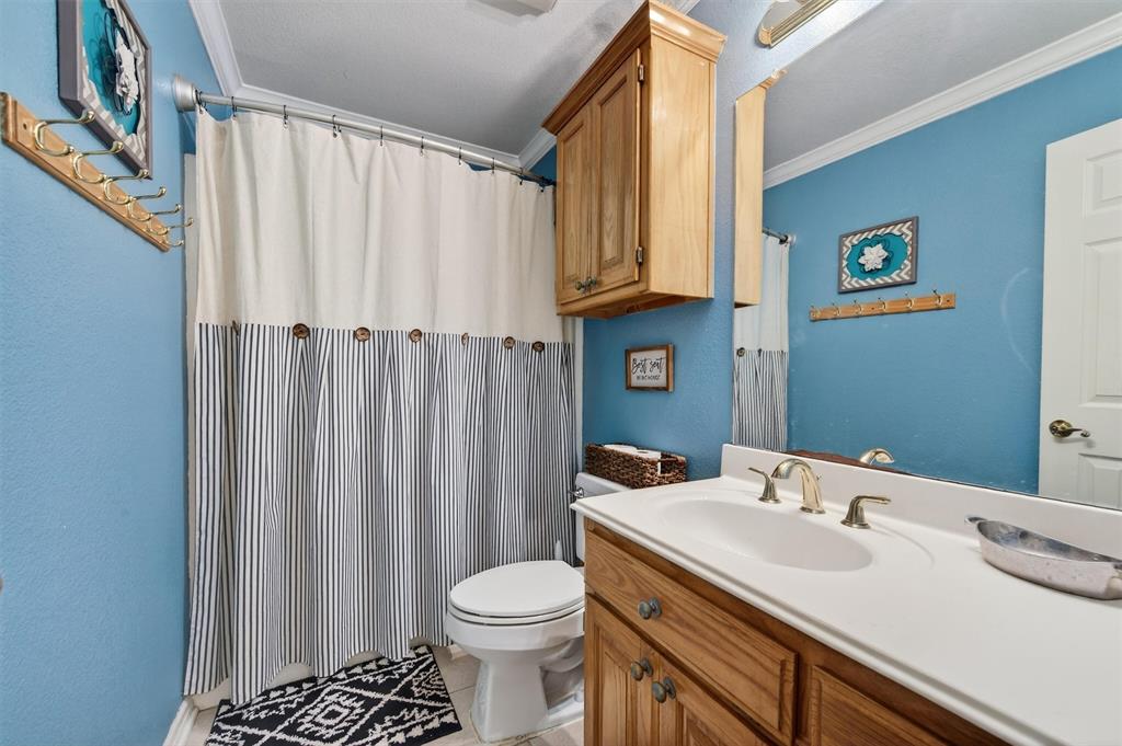 207 Gayle Circle Bells, TX 75414 - Photo 22 of 30 a bathroom with a sink a toilet and shower curtain
