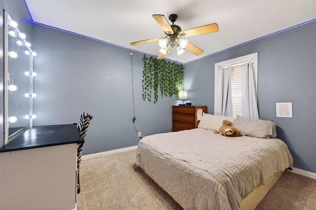 a bedroom with a bed and a flat tv screen on dresser
