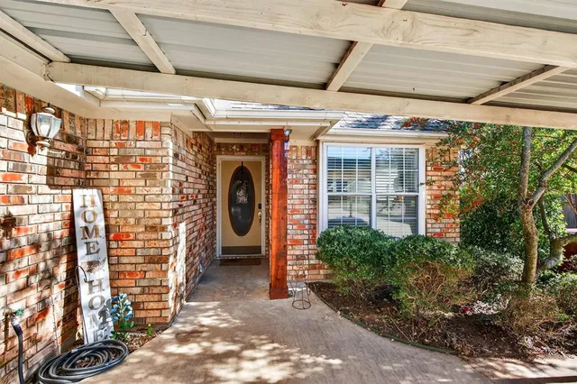 a view of a hallway to room with wooden floor and windows