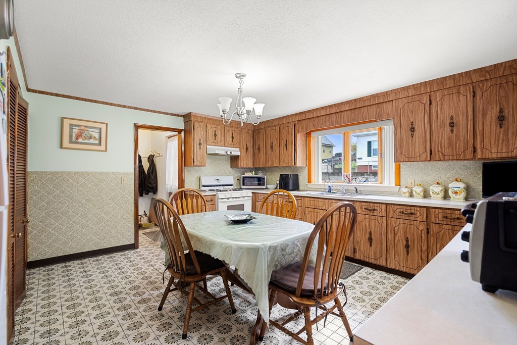 a kitchen with stainless steel appliances granite countertop a dining table chairs and a refrigerator