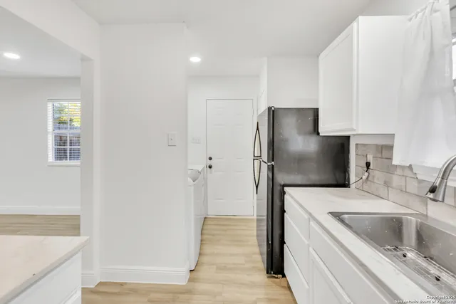 a kitchen with a refrigerator sink and cabinets
