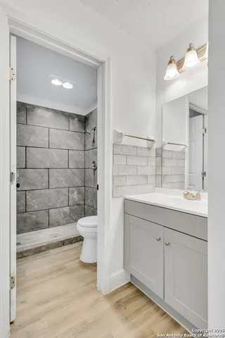 a bathroom with a sink a toilet and shower