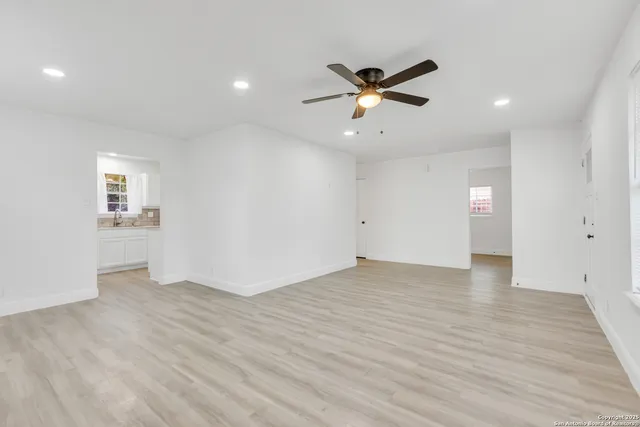 a view of an empty room with window and wooden floor