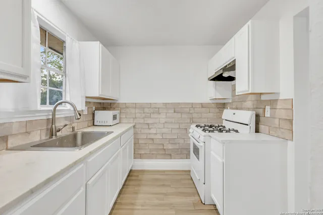 a kitchen with a sink stove and cabinets