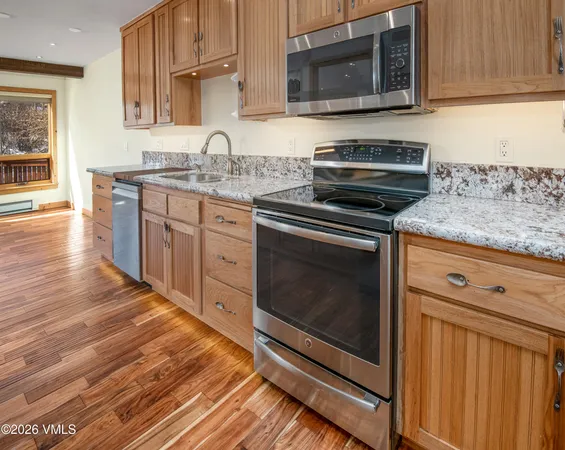 a kitchen with stainless steel appliances granite countertop a stove microwave and sink