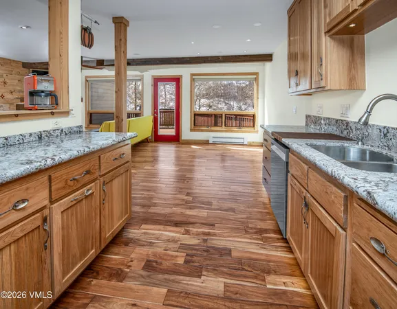 a kitchen with stainless steel appliances granite countertop a sink and a wooden cabinets