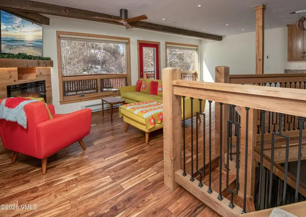a living room with furniture a rug and a floor to ceiling window