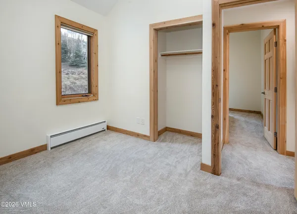 an empty room with closet and a window