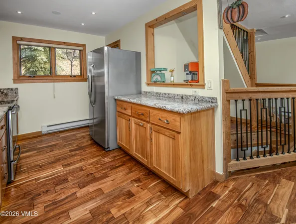 a view of a kitchen with wooden floor and stairs