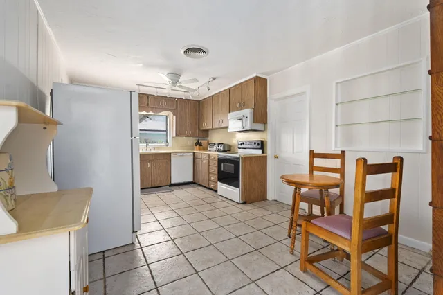 a kitchen with cabinets and chairs
