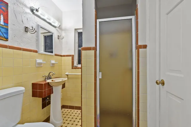 a bathroom with a sink a toilet and shower