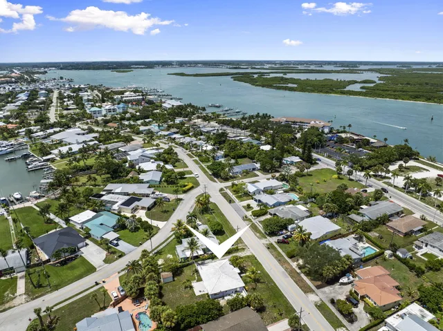 an aerial view of residential houses with outdoor space and ocean view
