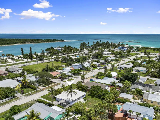 an aerial view of a city with lots of residential buildings and ocean view in back