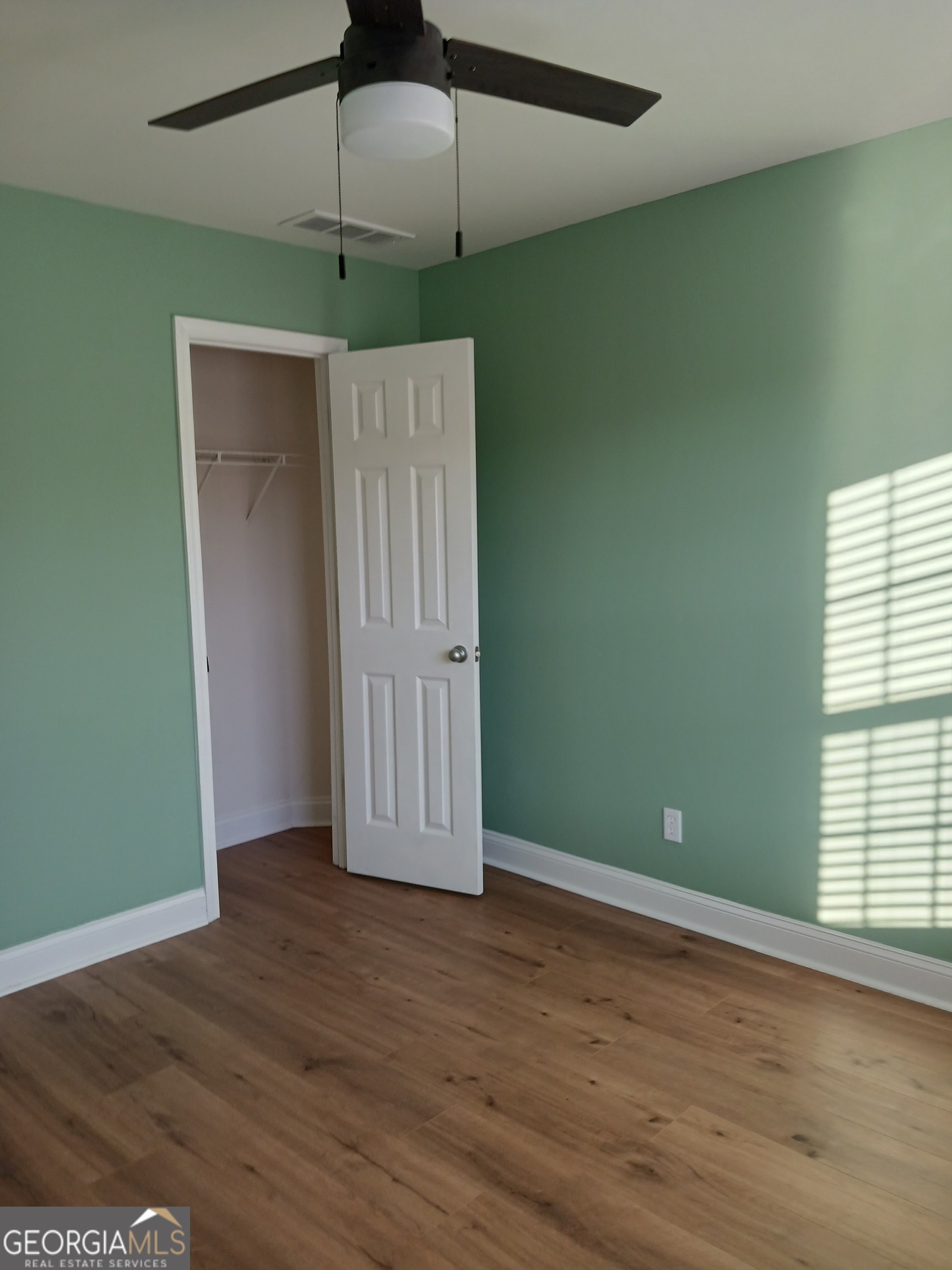 907 Downing Drive Bethlehem, GA 30620 - Photo 18 of 26 an empty room with wooden floor fan and windows