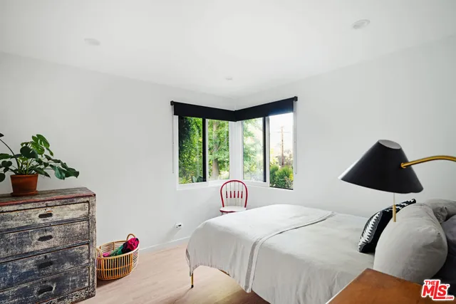 a bedroom with a bed and a potted plant