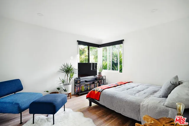 a bedroom with a bed and a flat screen tv