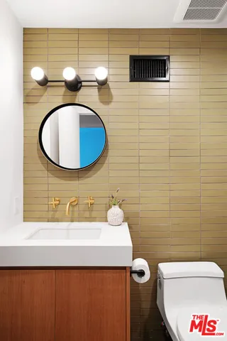a bathroom with a sink mirror vanity and toilet