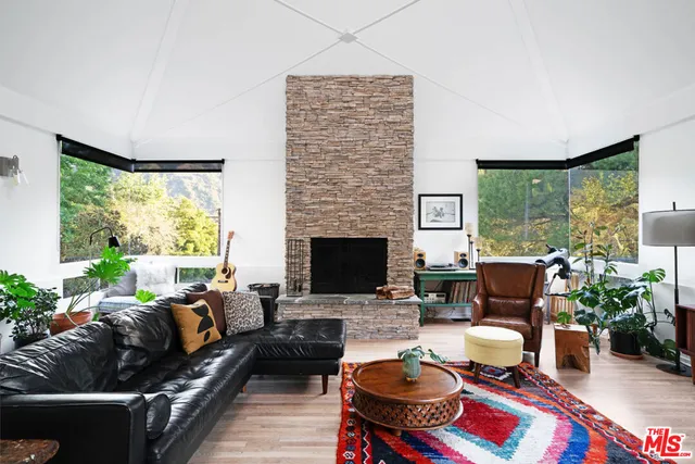 a living room with furniture fireplace and a large window