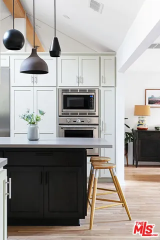 a kitchen with stainless steel appliances a stove a microwave and wooden floor