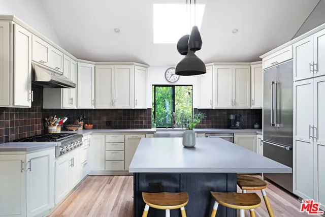 a kitchen with stainless steel appliances a center island cabinets and wooden floor