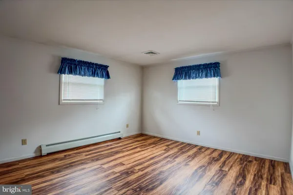 a view of a room with wooden floor and a ceiling fan