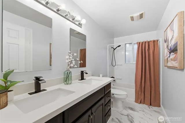 a bathroom with a granite countertop sink a toilet and a mirror