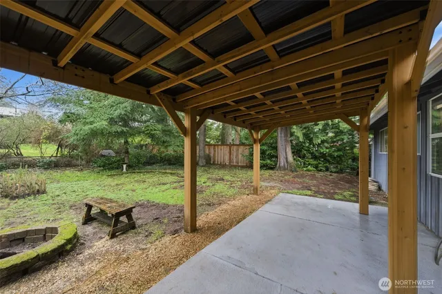 a view of a backyard with table and chairs under an umbrella