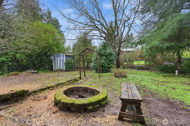 a backyard of a house with barbeque oven and swing