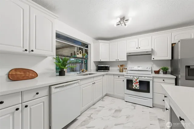 a kitchen with white cabinets and white appliances