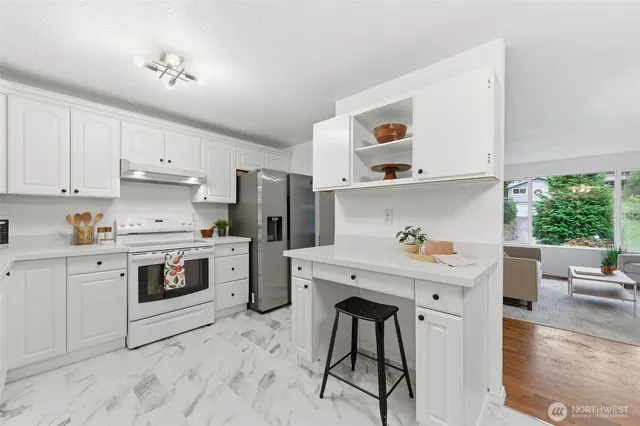 a kitchen with a white stove top oven and white cabinets