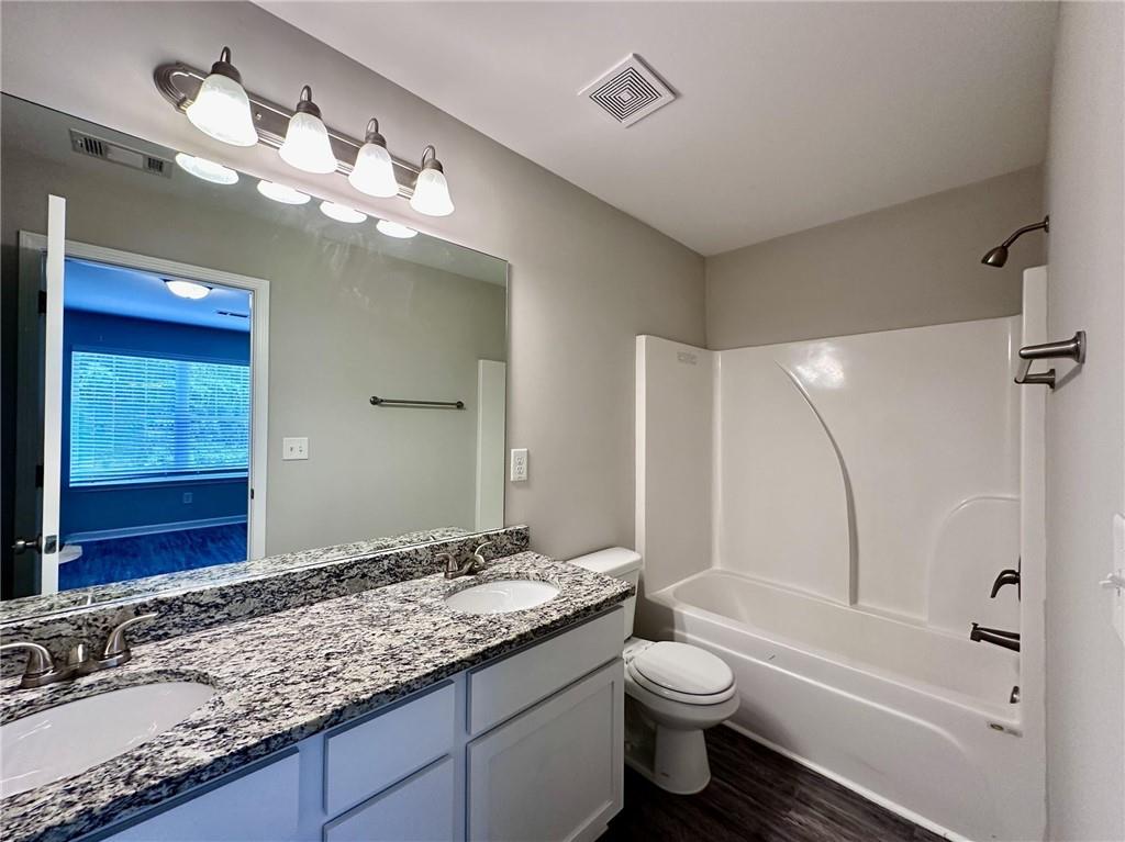722 Keeshono St Union Union City, GA 30291 - Photo 5 of 7 a bathroom with a granite countertop toilet sink and mirror