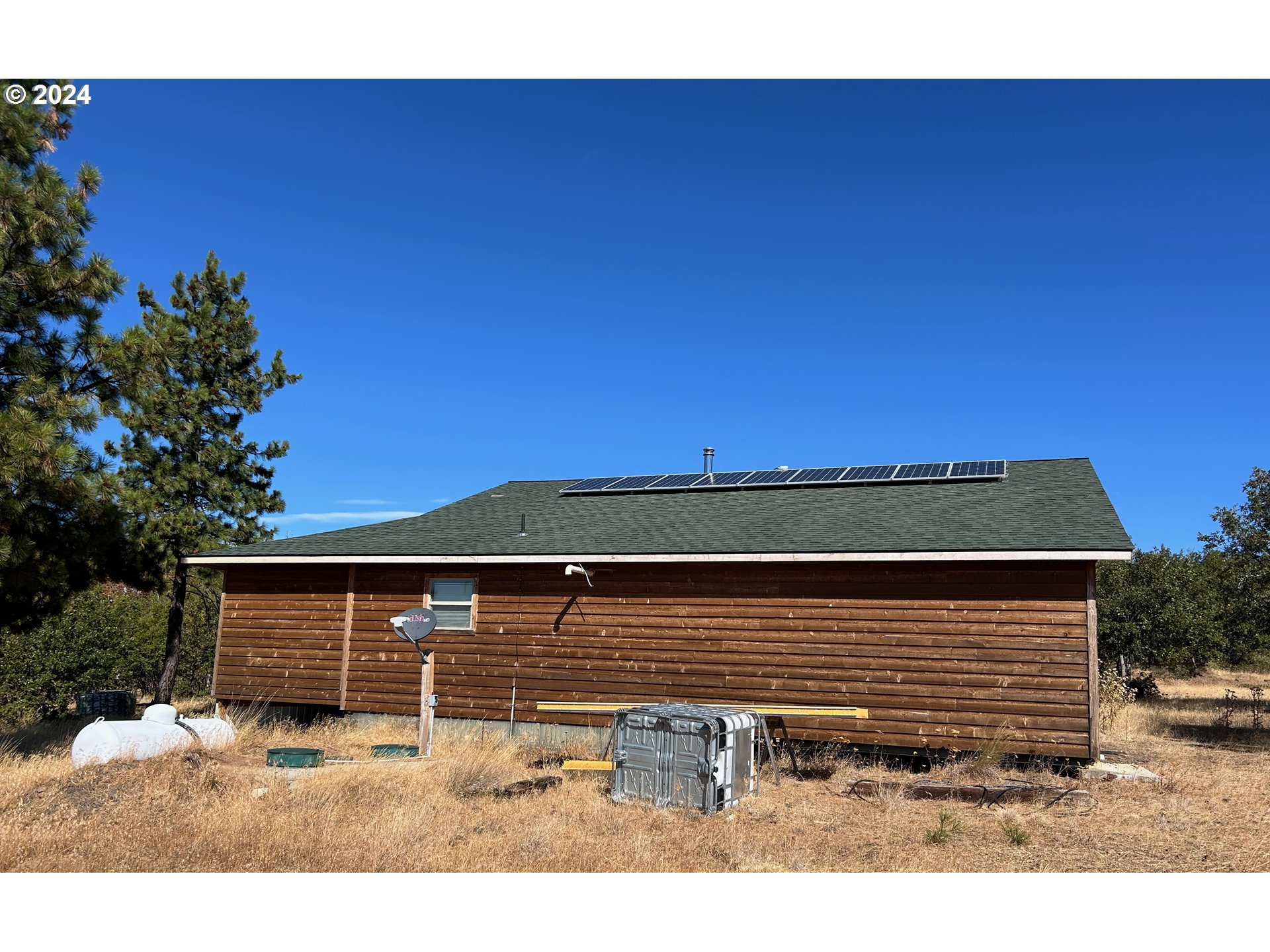 211 Jensen Quarry Road Roosevelt, WA 99356 - Photo 5 of 27 a view of a backyard with a large tree