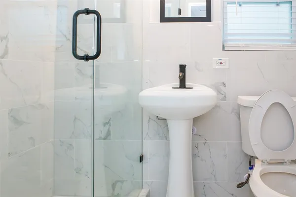 a bathroom with a sink a toilet and shower