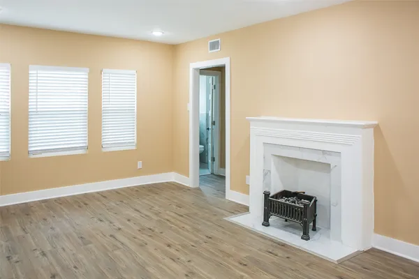 a view of a livingroom with wooden floor and a bedroom