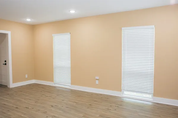 a view of an empty room with wooden floor