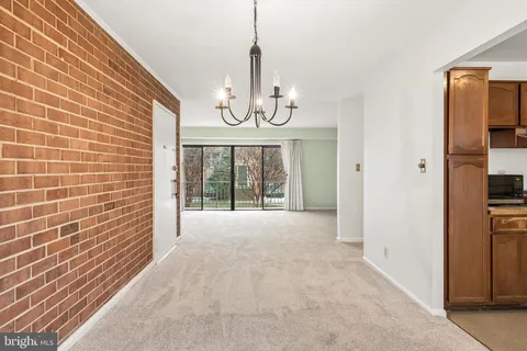 a view of an empty room with chandelier and a window