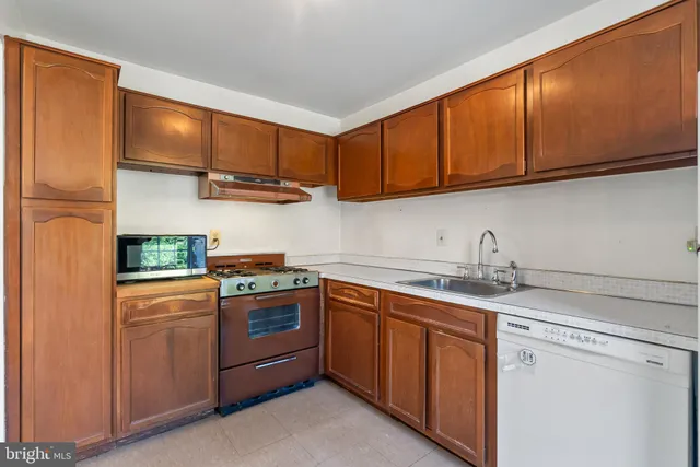 a stove top oven sitting inside of a kitchen
