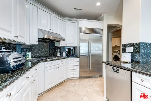 a kitchen with stainless steel appliances granite countertop a refrigerator sink and cabinets