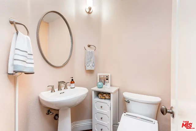 a bathroom with a sink a toilet and a mirror