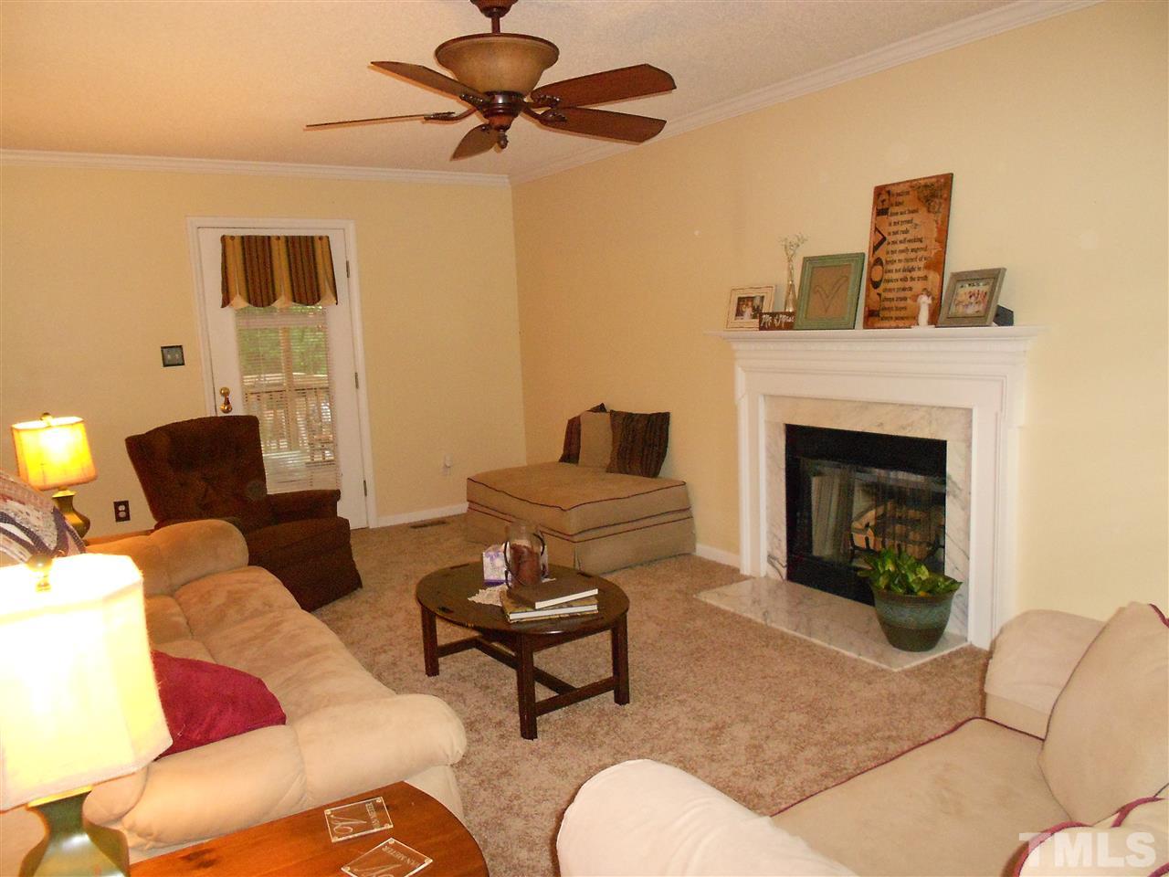 A spacious living room with gas log fire place.