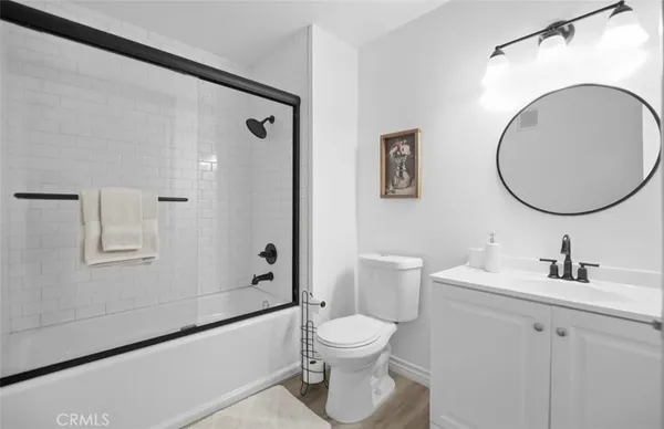 a bathroom with a toilet sink vanity tub and shower
