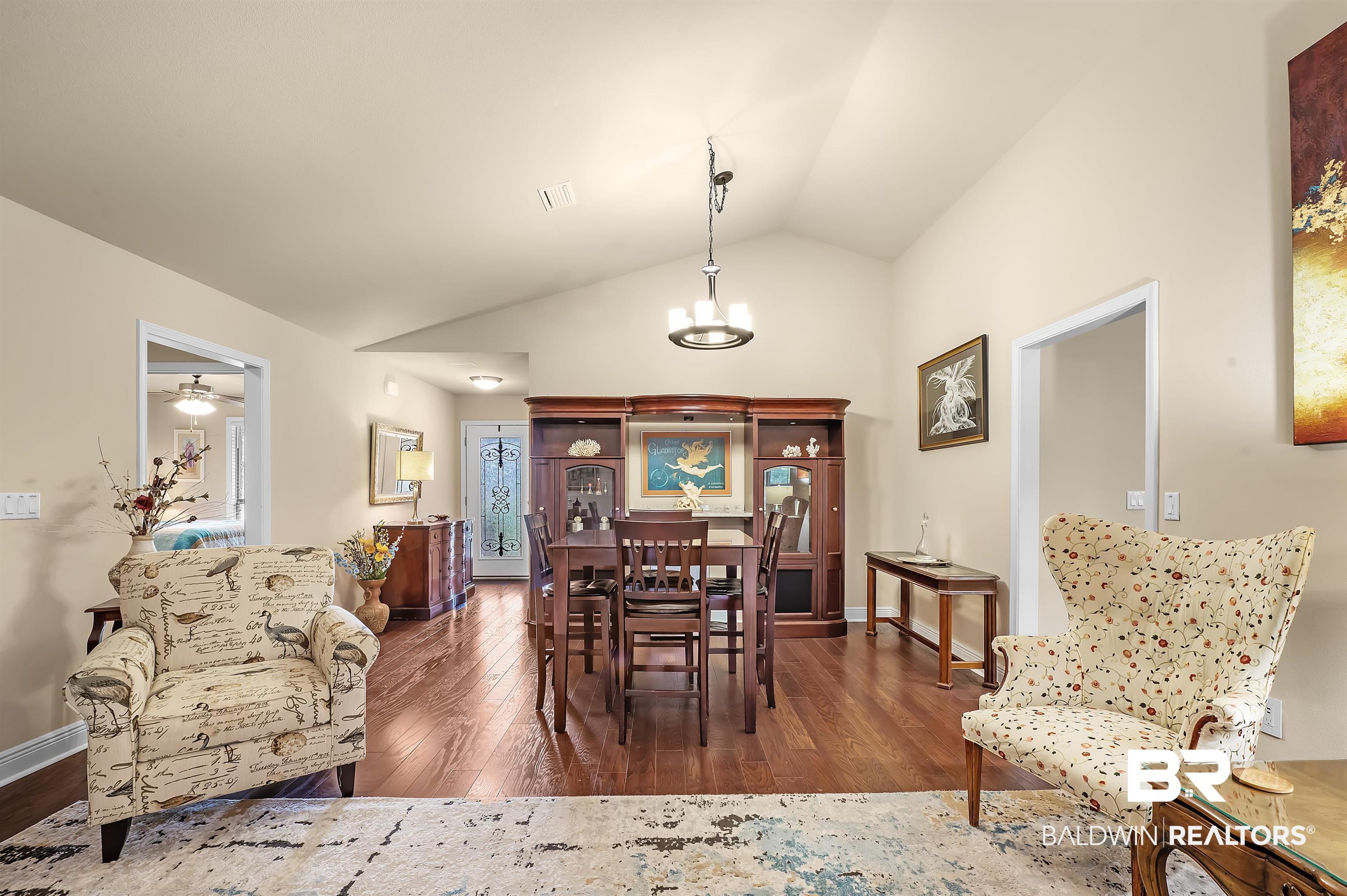 8896 Allay Lane Foley, AL 36535 - Photo 26 of 57 Dining room with lofted ceiling, dark wood-type flooring, and ceiling fan with notable chandelier