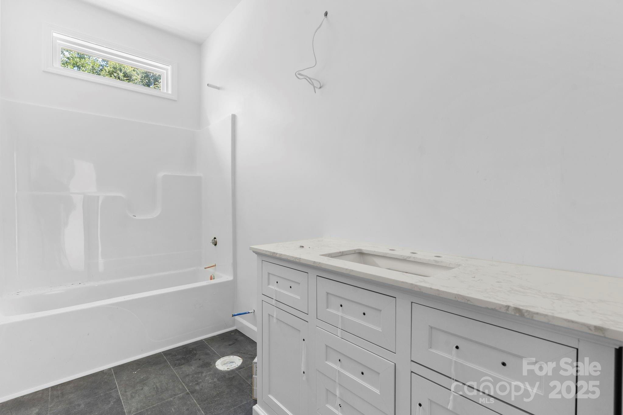 3137 Riber Lane Claremont, NC 28610 - Photo 22 of 25 a bathroom with a granite countertop sink and a bathtub