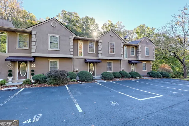 a front view of a house with yard and parking